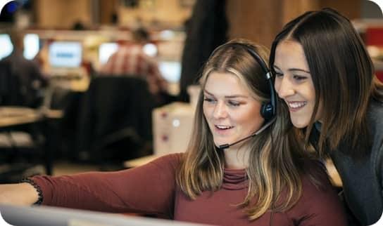 Two women looking at a computer screen together.