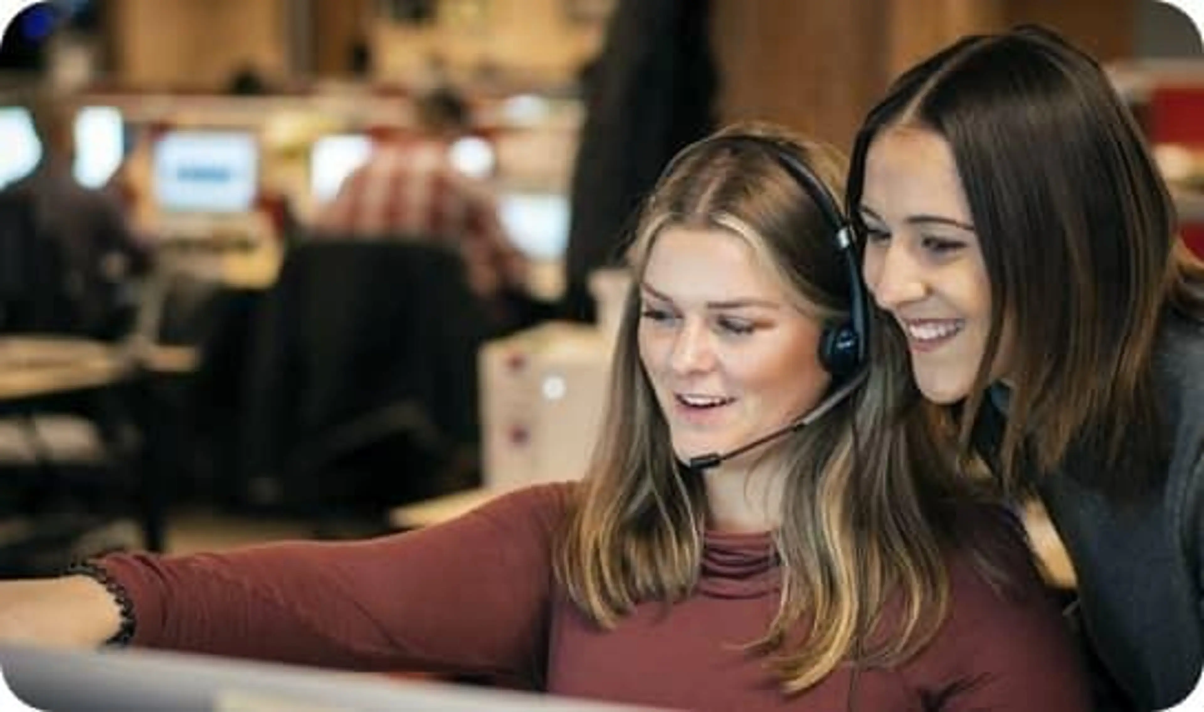Two women looking at a computer screen together.