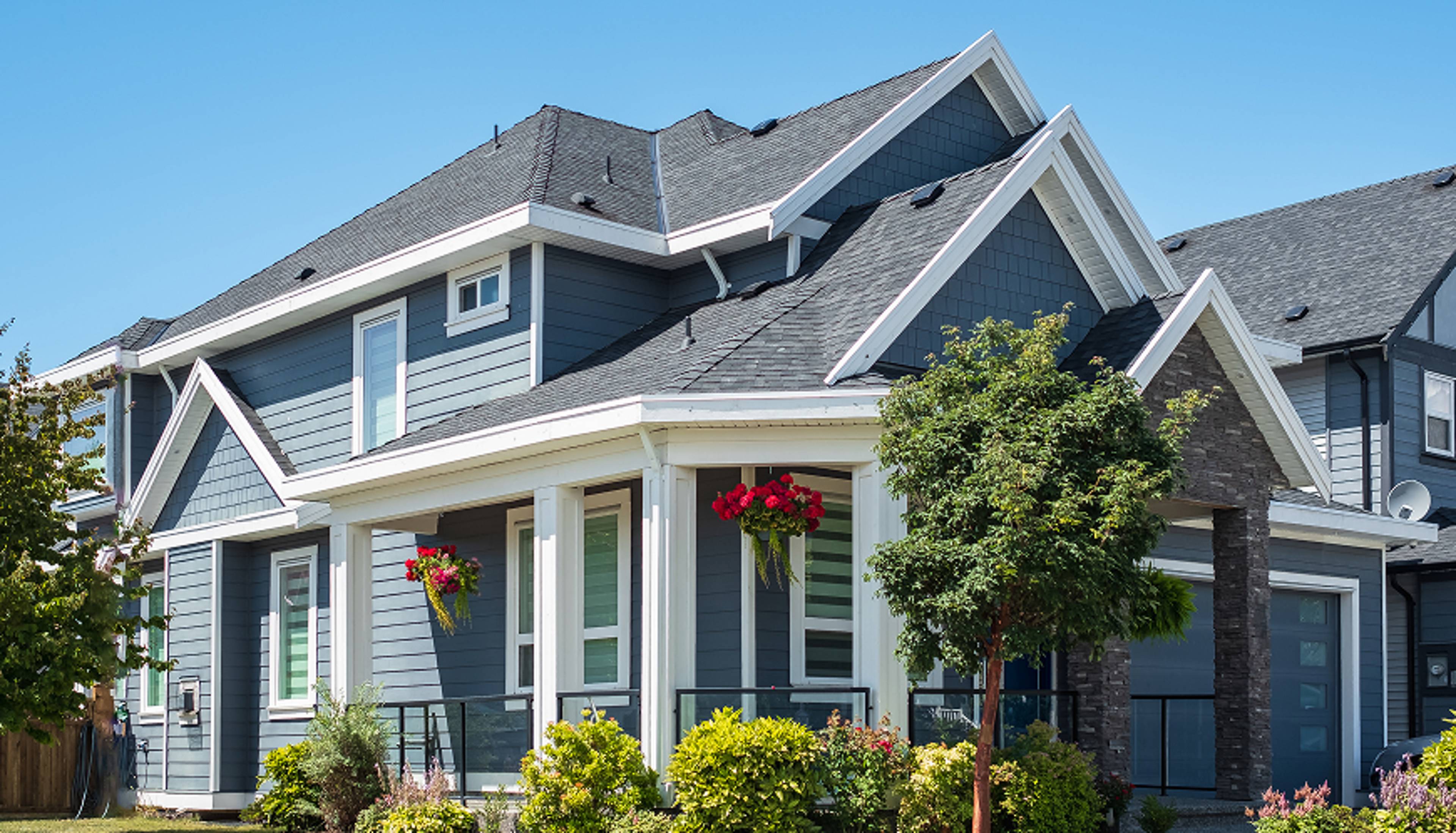 Two-story home with bushes out front.
