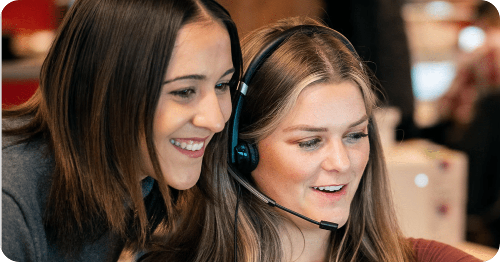 Two Rate employees look at a computer screen together.
