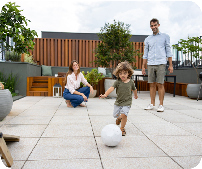 Family in backyard with baby kicking soccer ball