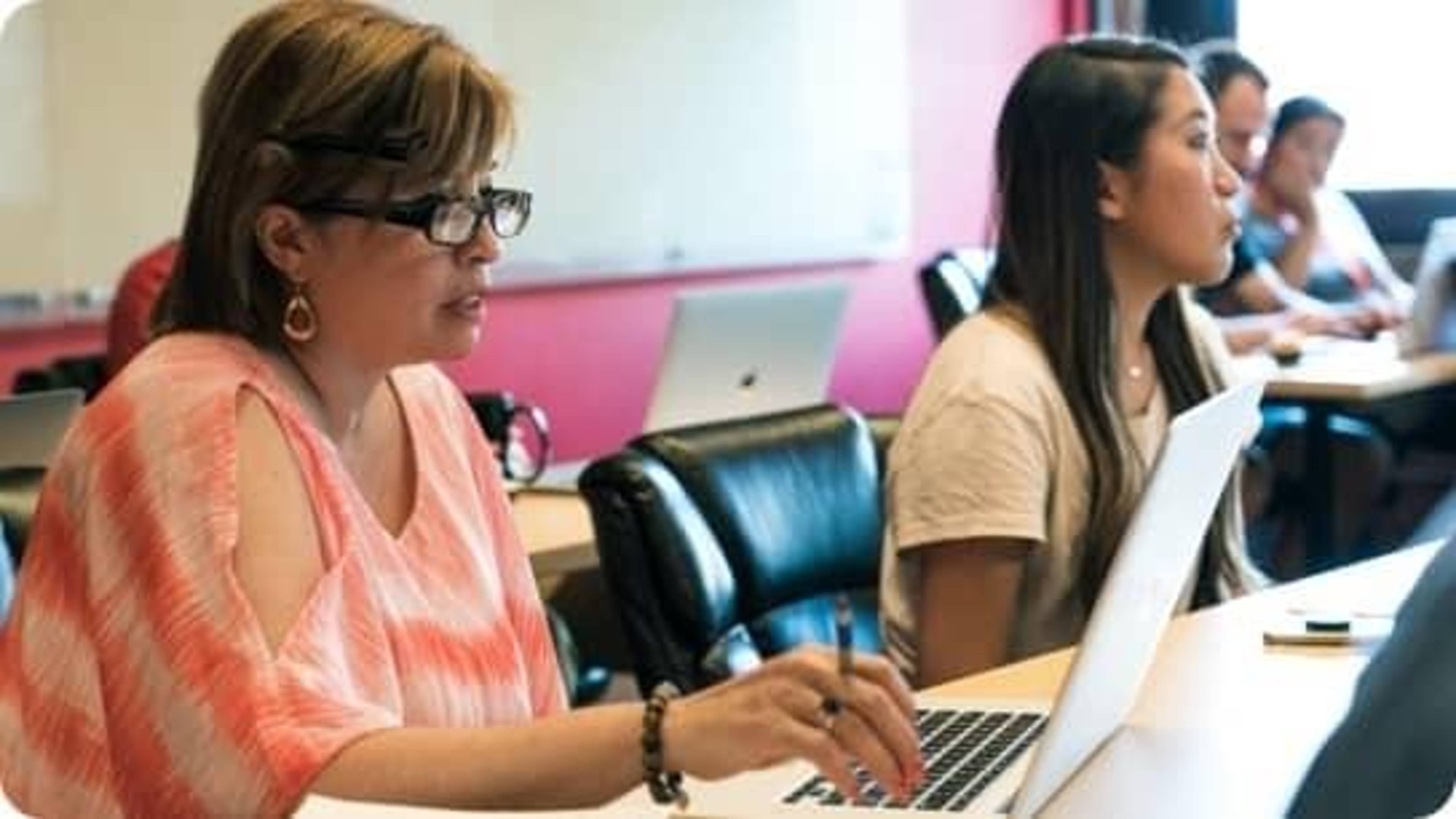 Two Rate employees using their laptops.