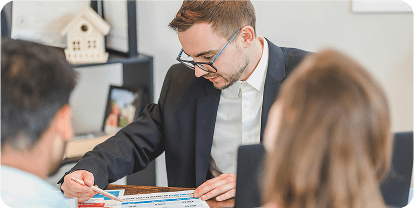 A financial advisor looks over paperwork with a couple