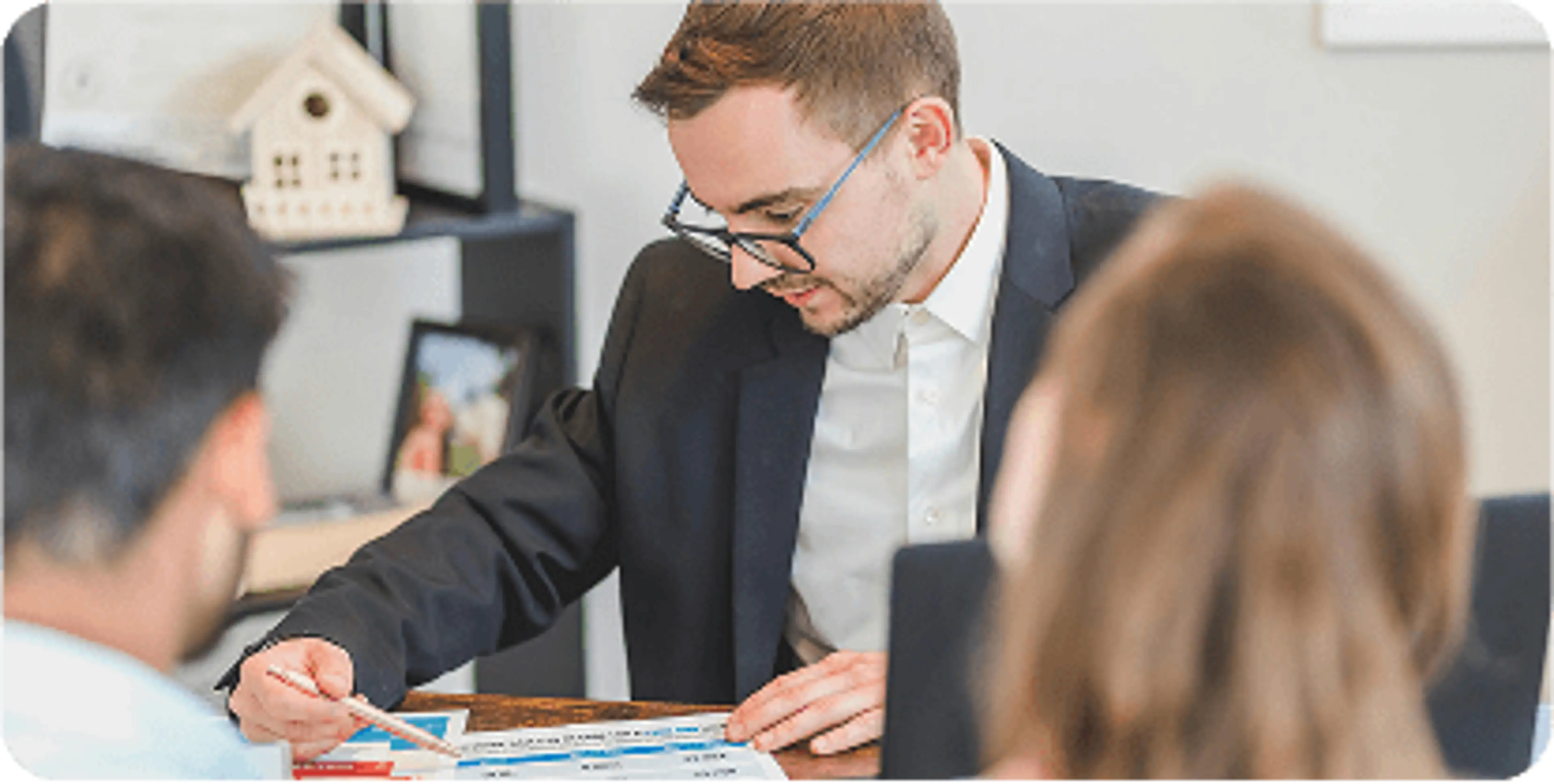 A financial advisor looks over paperwork with a couple
