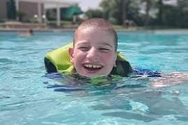 A young boy swimming in a pool.