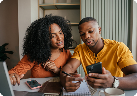2 people looking at a phone while planning