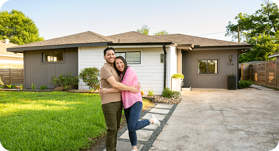 Couple hugging in front of new home
