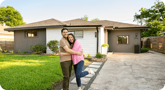 Couple hugging in front of new home