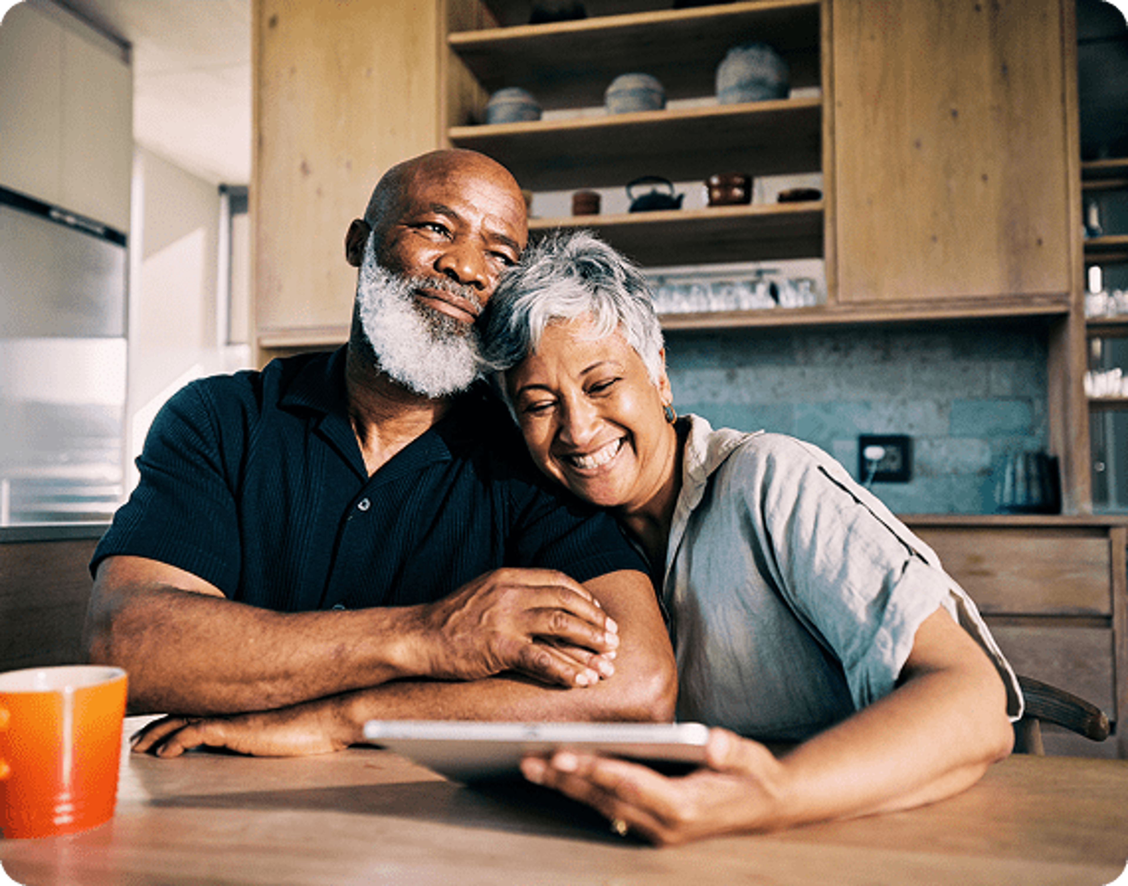 A Couple smiling while looking at a tablet screen