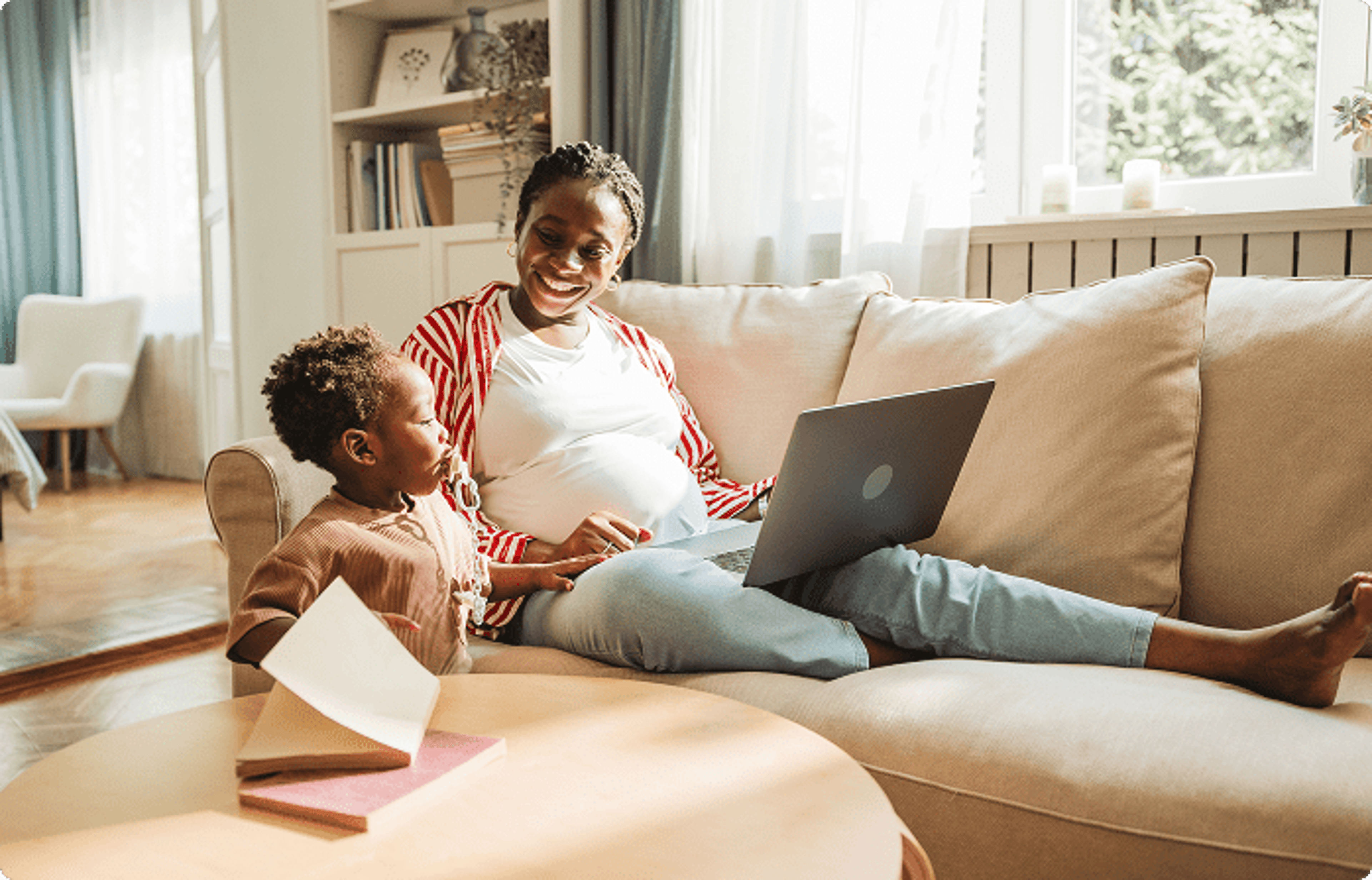 Pregnant mom on laptop next to child