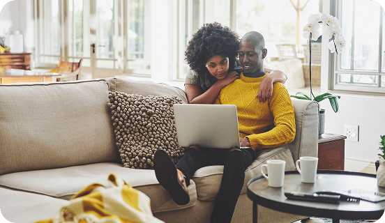 Couple on the couch looking at a laptop