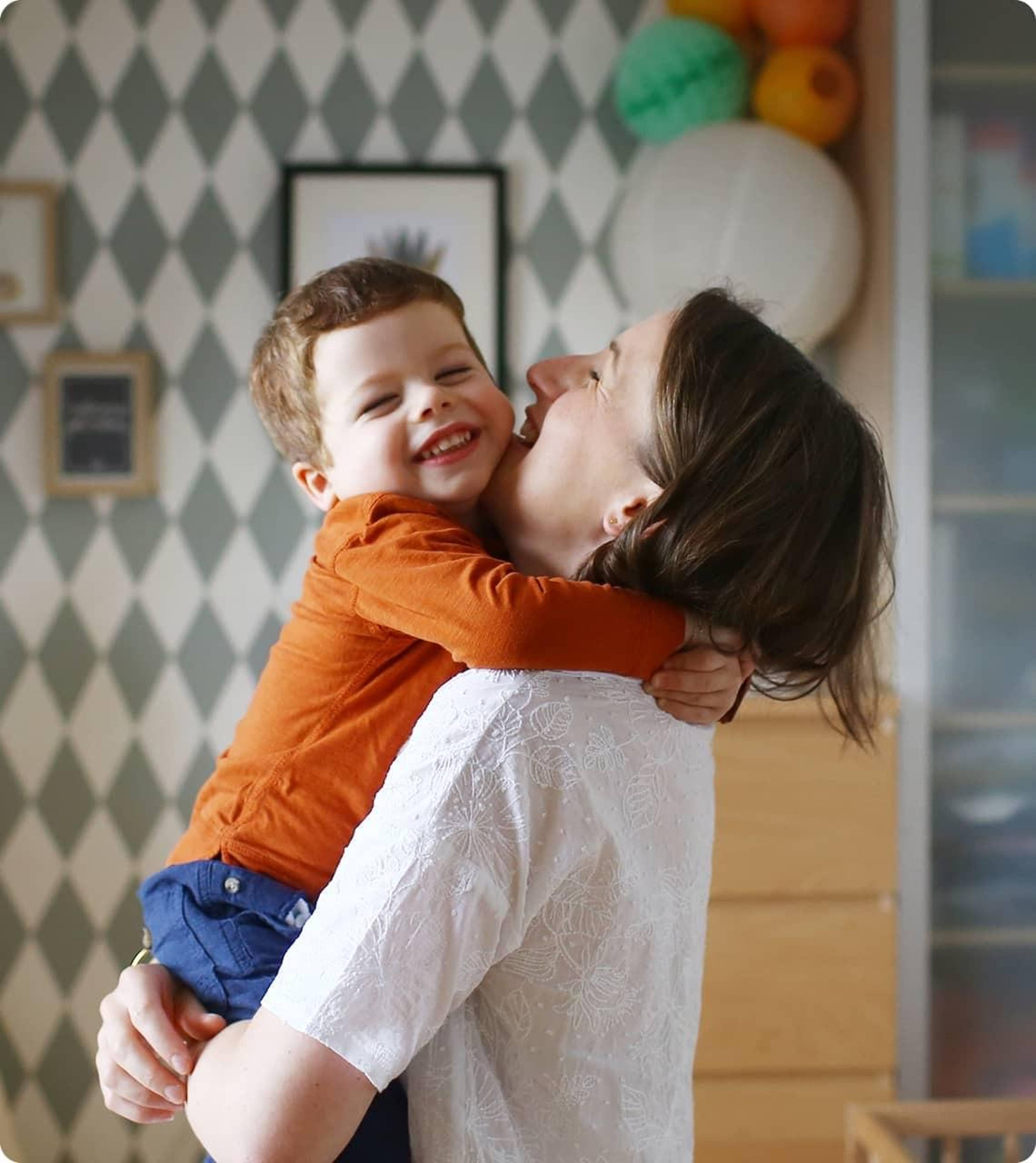 woman hugging happy baby