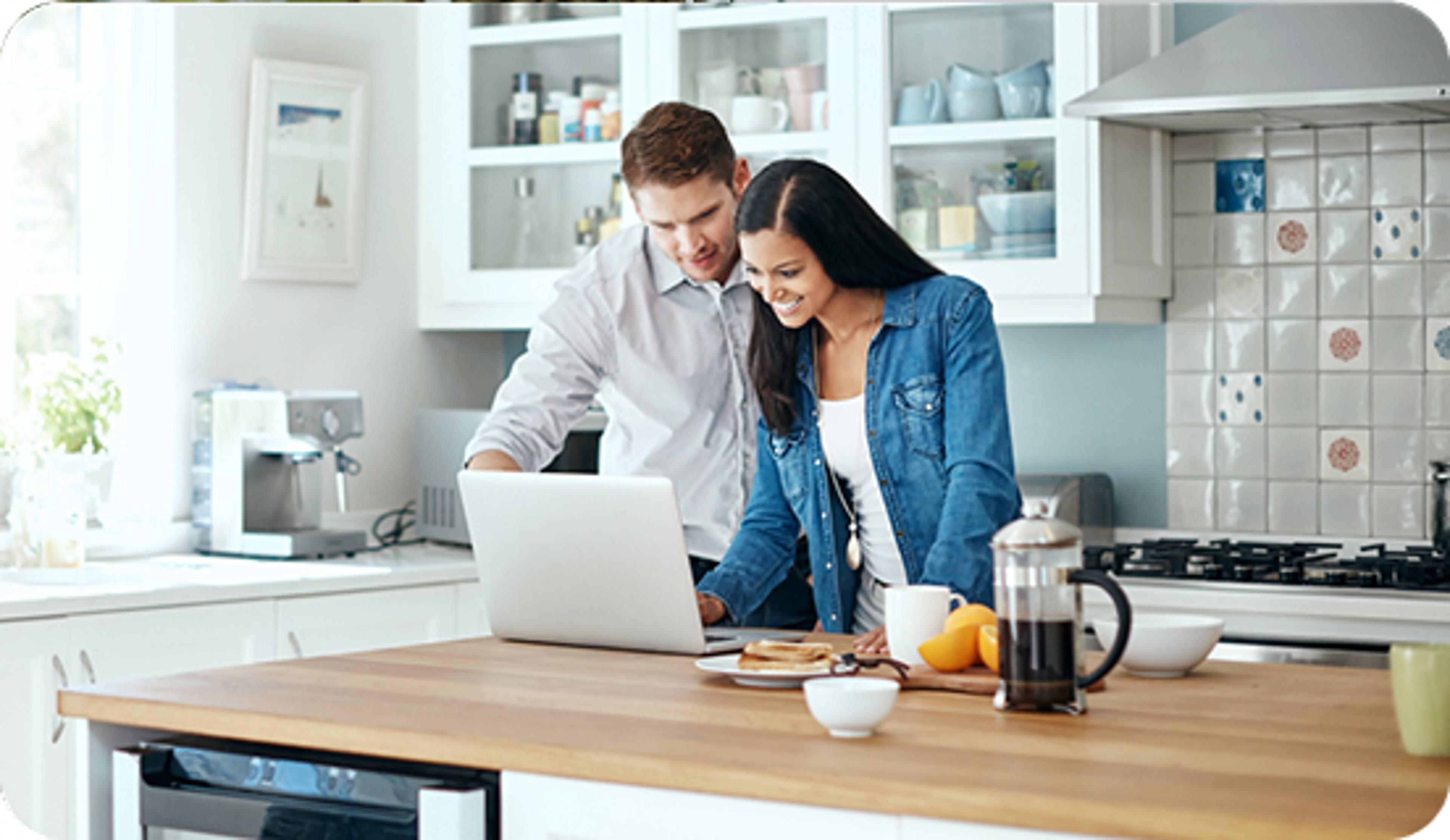 Couple on their laptop in the kitchen.