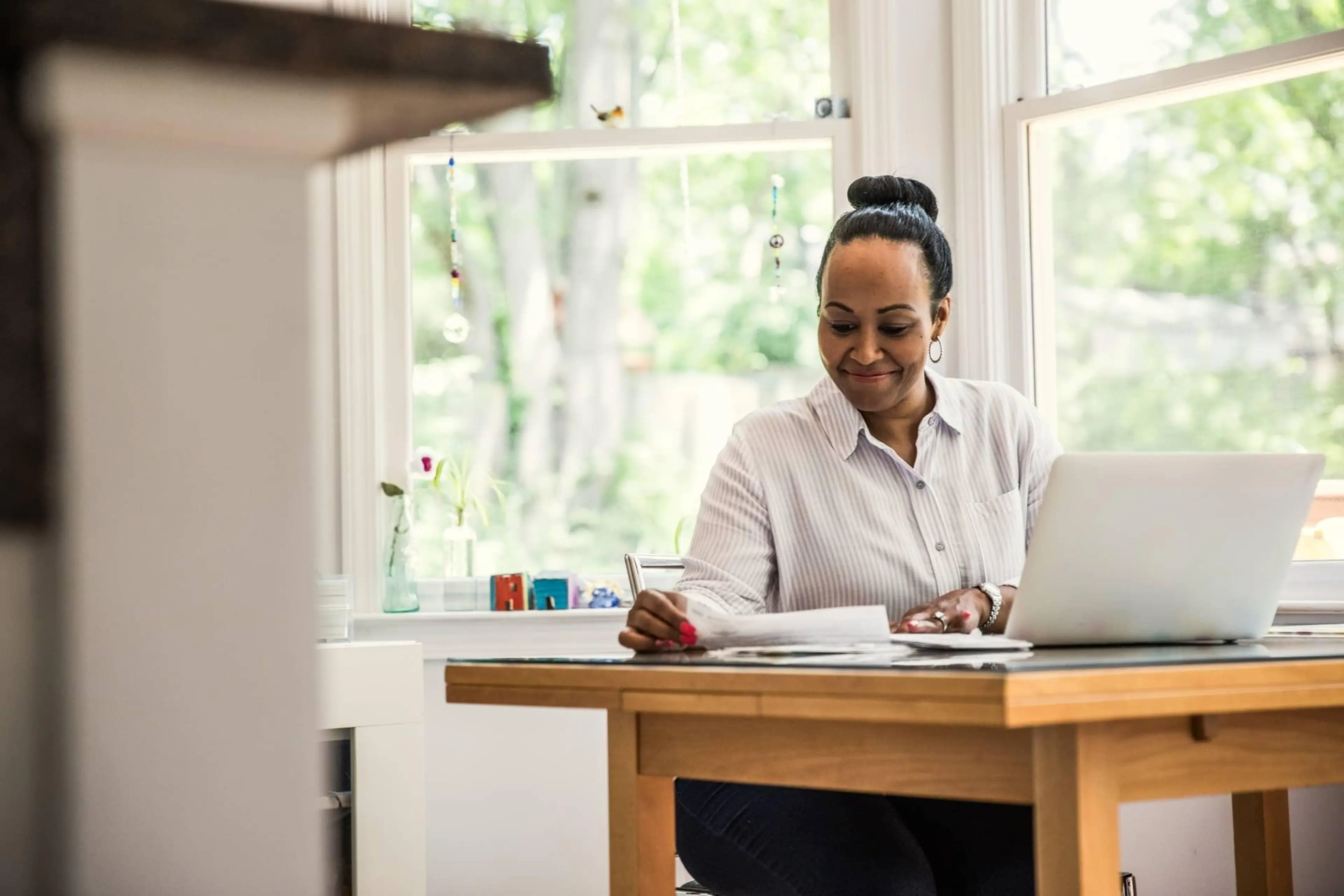A person sitting at a table while reviewing paper documents.