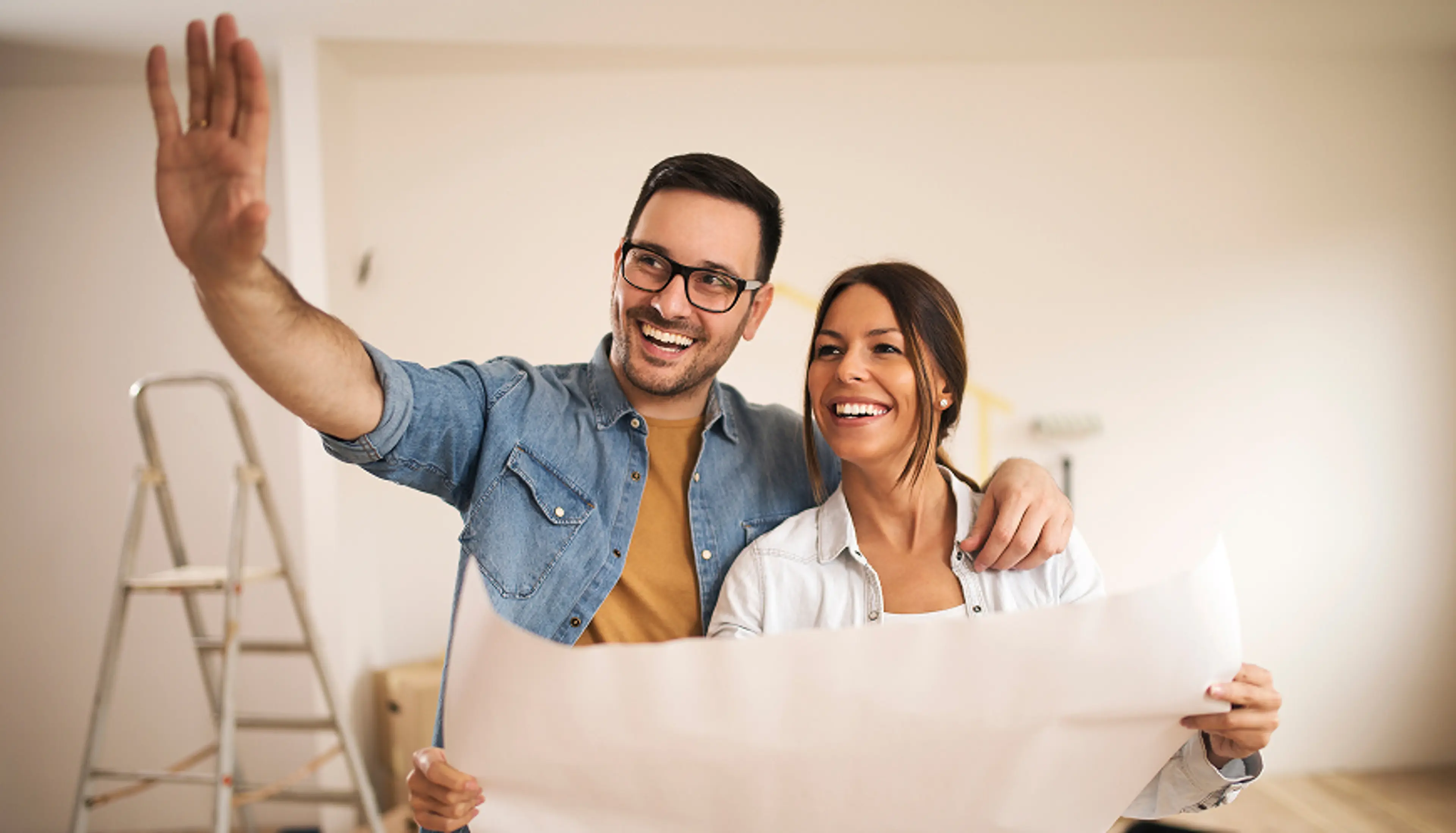 A couple looks at blueprints for a home.
