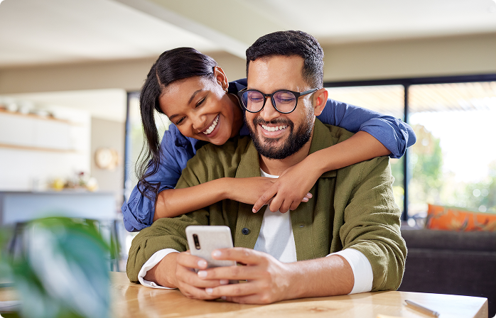 Rate Bridge - Couple hugging and looking at the phone.