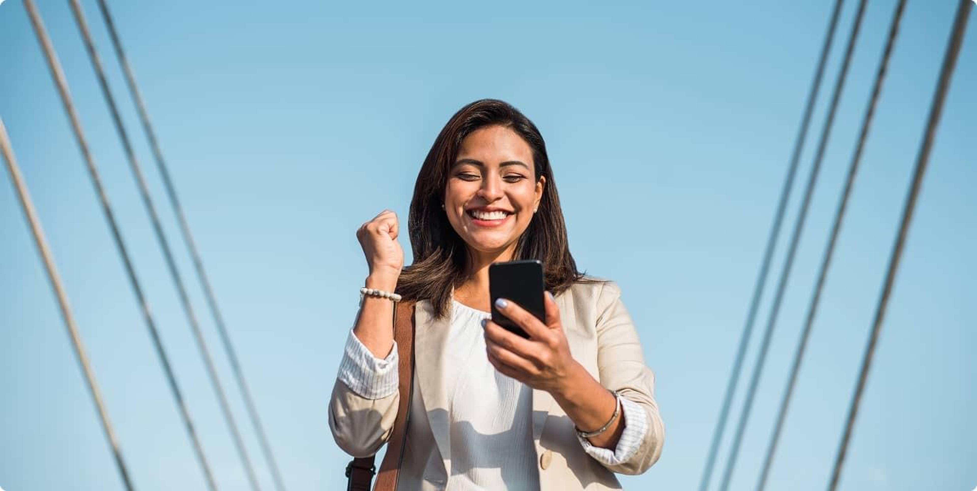 A person excitedly looks at their phone smiling.