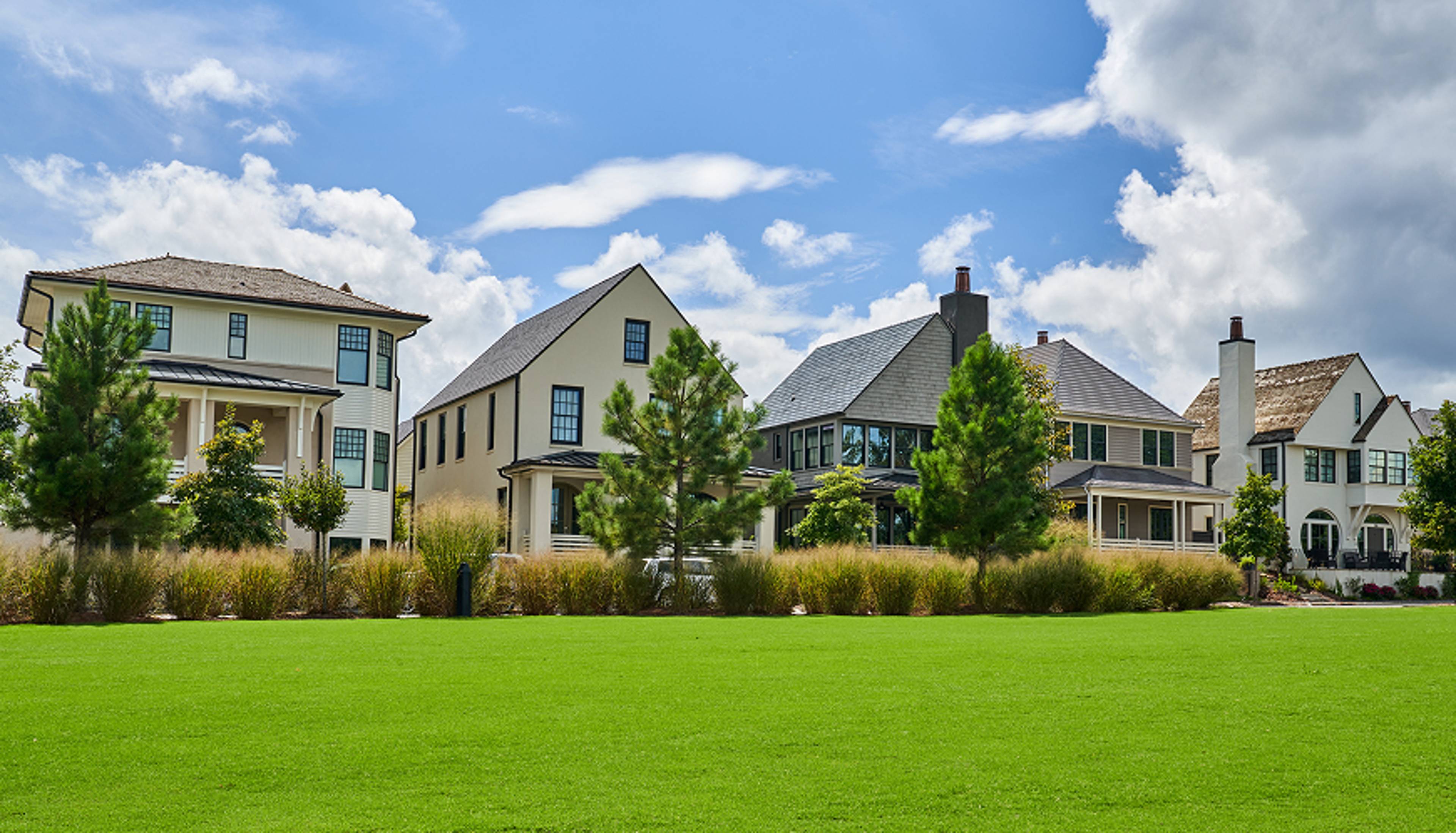 Multiple homes in a suburb with a large lawn.