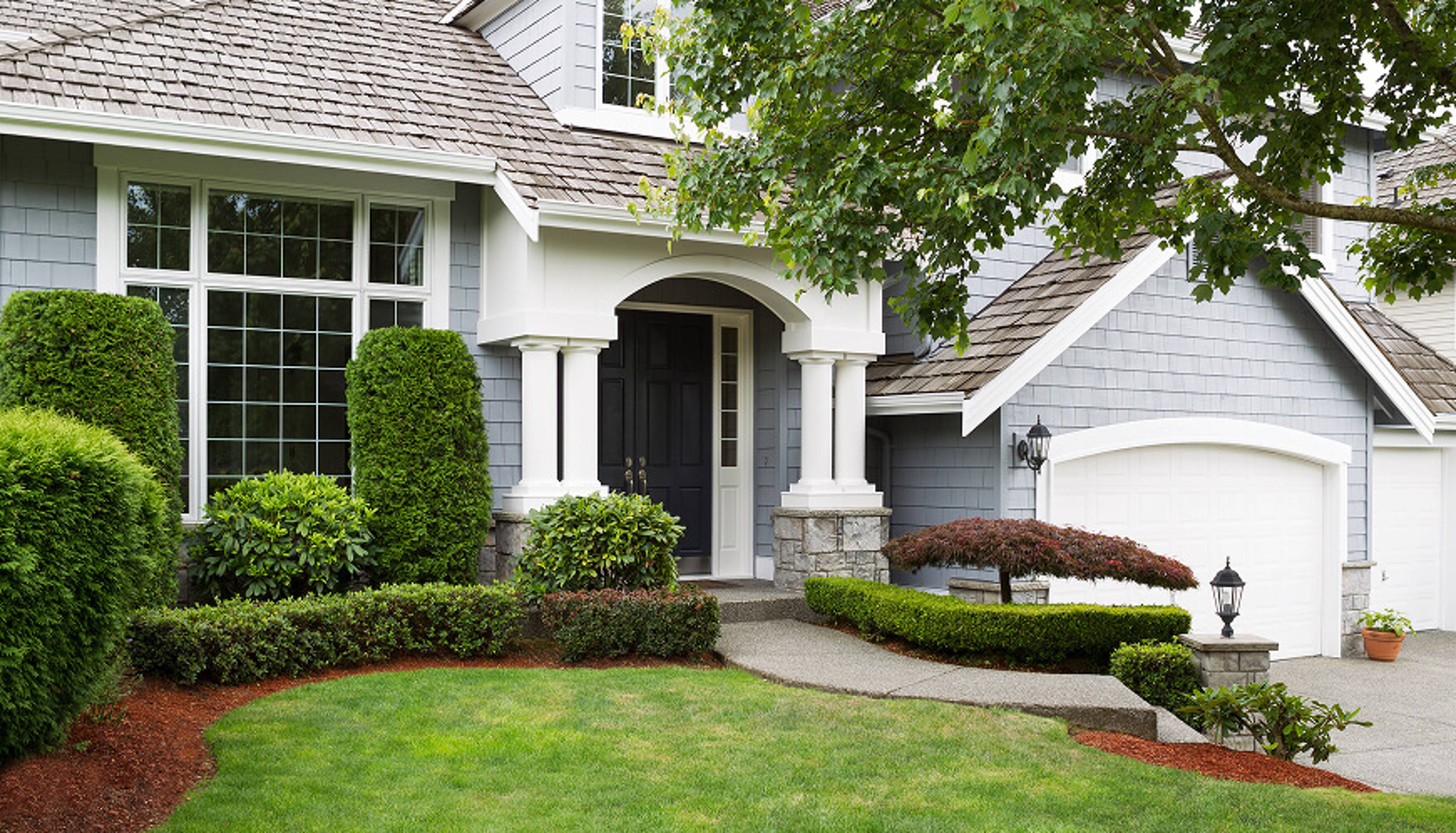 Light blue house with green grass.