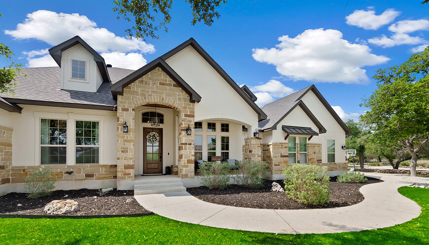Front of a beautiful house under the blue sky.