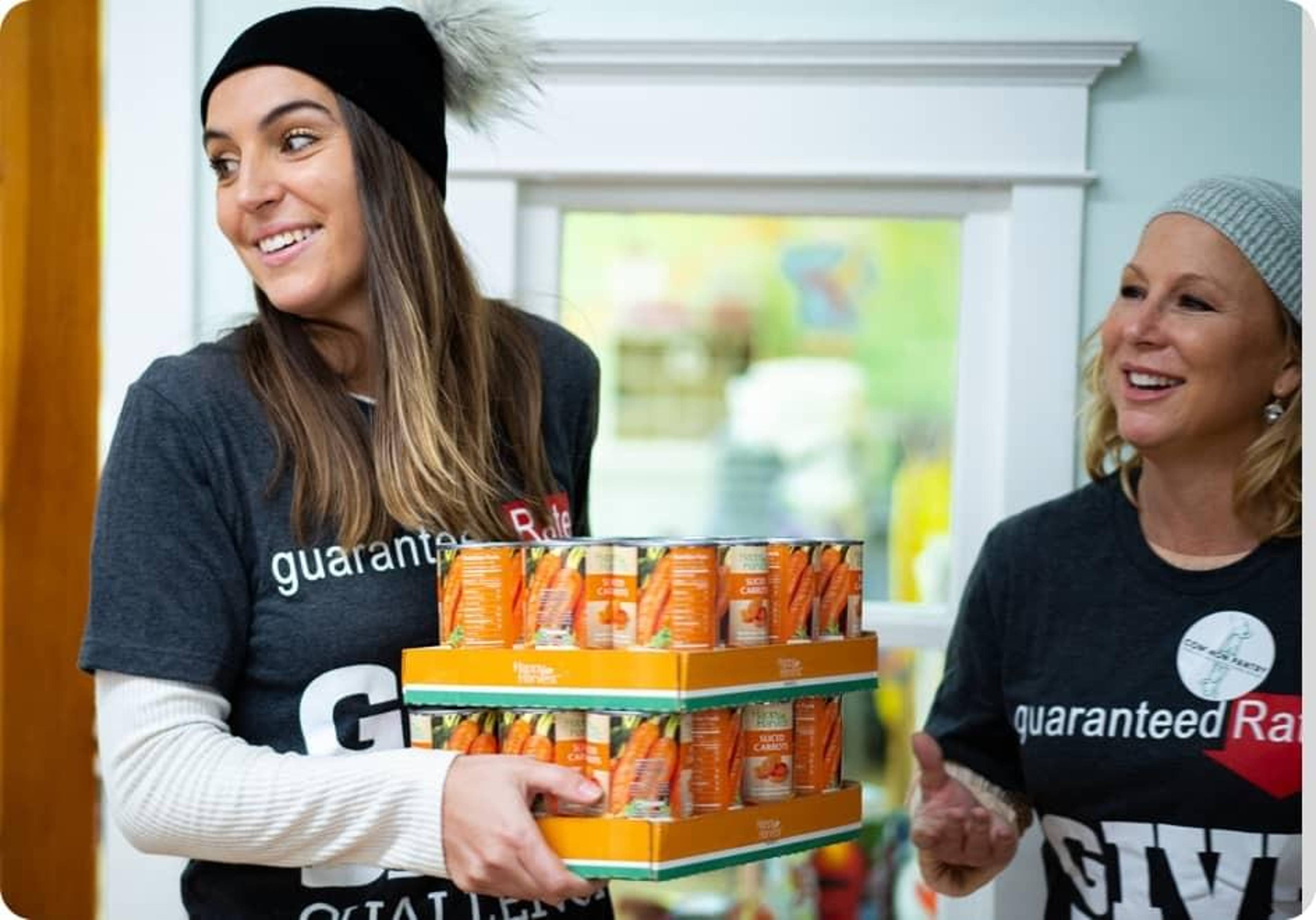 A Rate employee carries boxes of canned goods.
