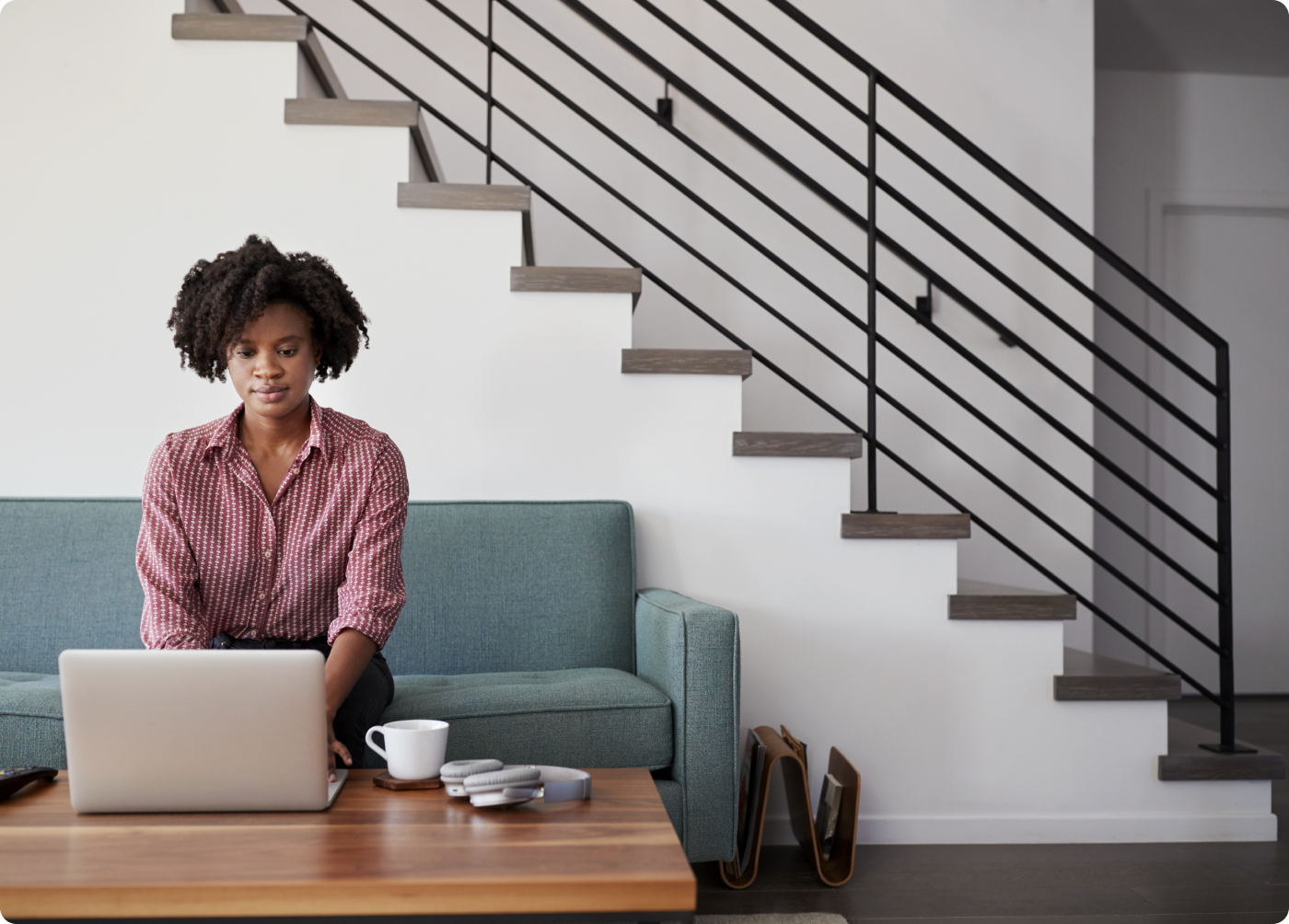 woman sitting on couch and using a laptop