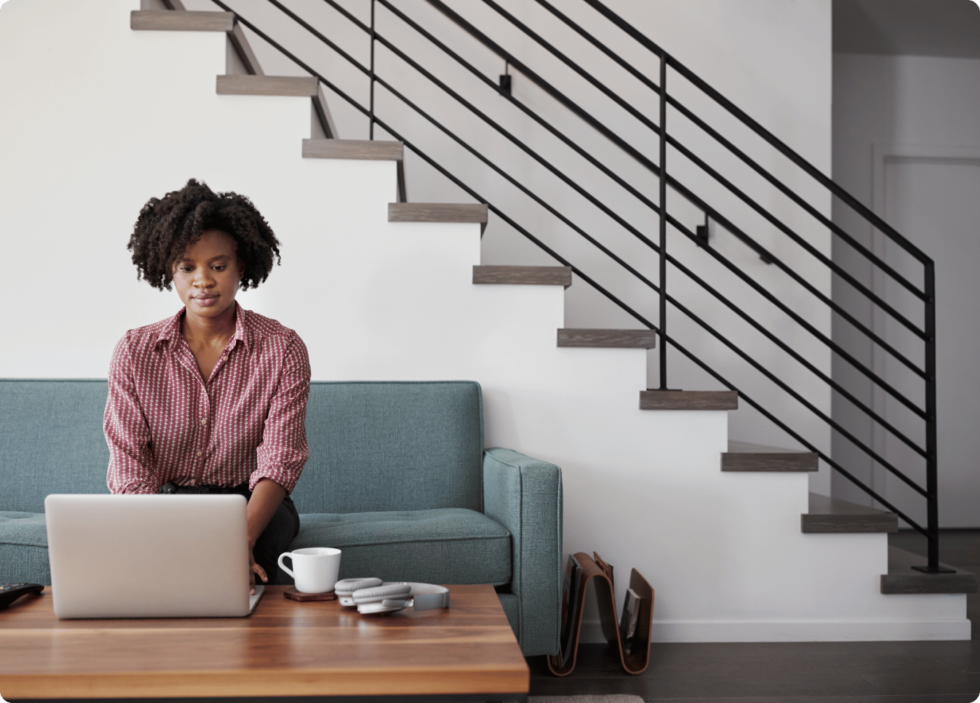woman sitting on couch and using a laptop
