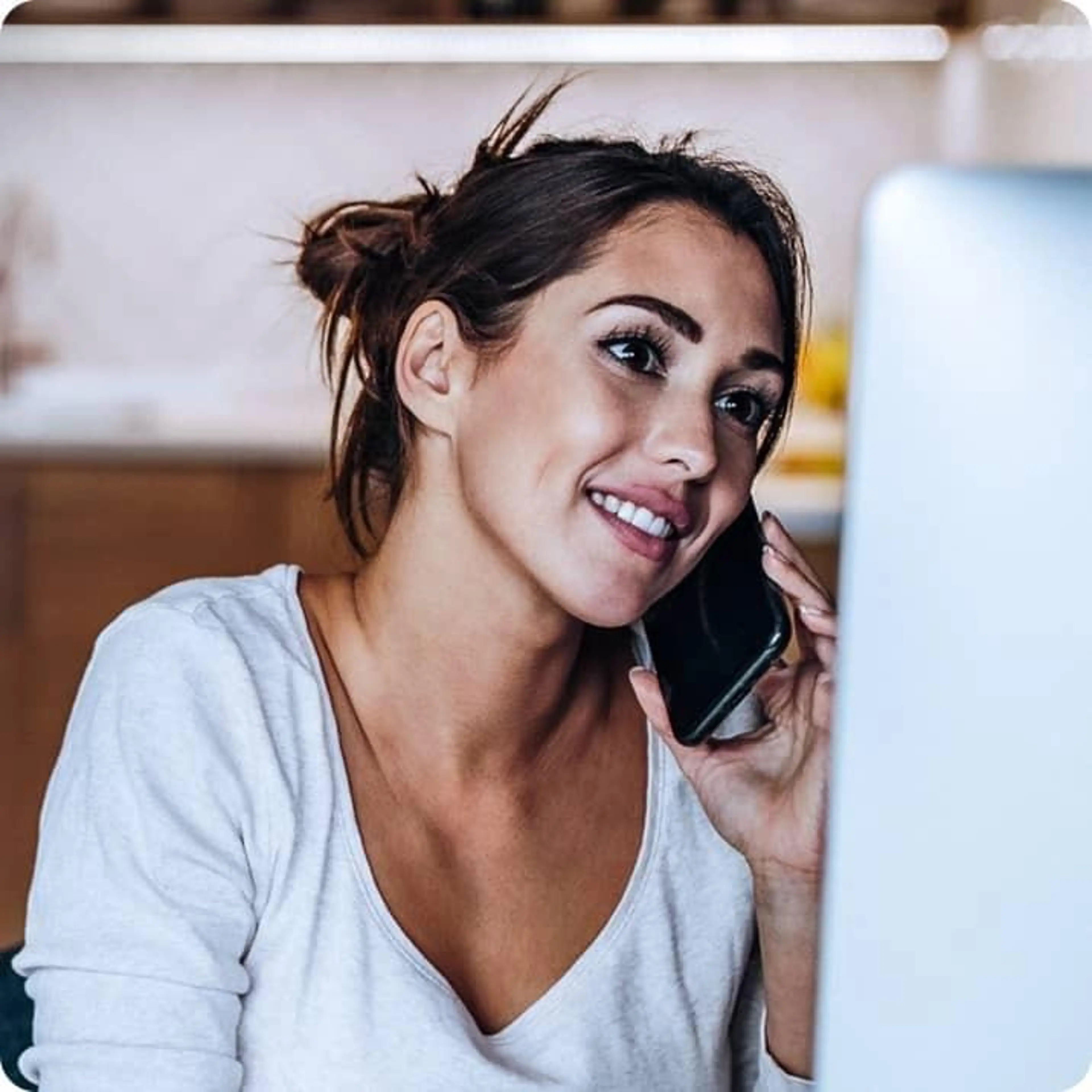 Person smiling while speaking to someone on their cell phone.