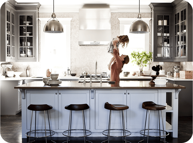 Woman throwing child up in the air to catch in the kitchen