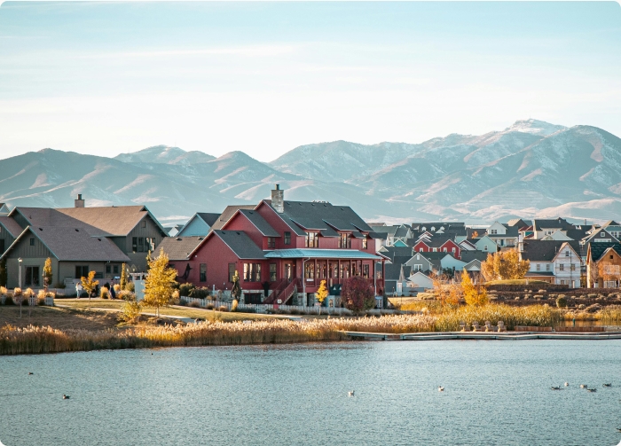 Hero image, homes with a lake in the middle and mountains in the back