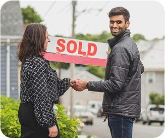 Couple holding Sold sign