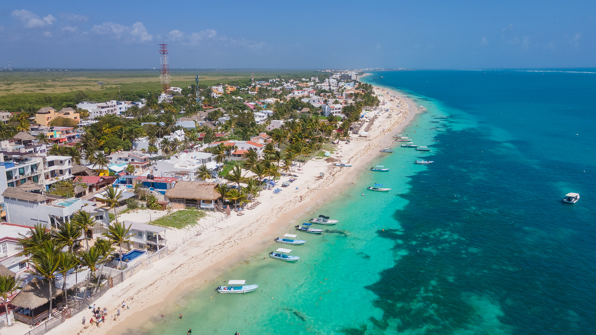 Aerial view of Puerto Morelos, a quiet coastal village bordered by turquoise waters and white-sand beaches.