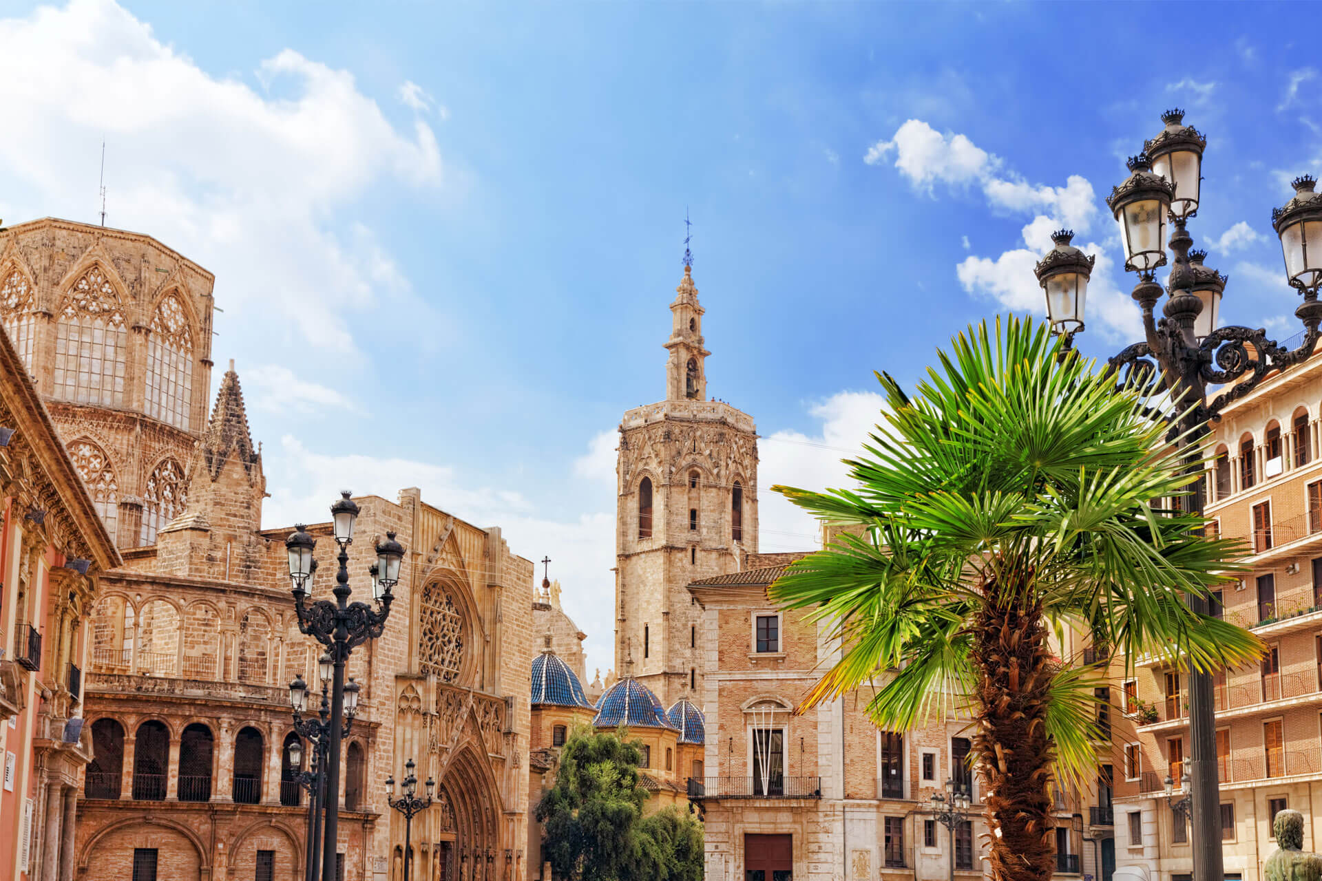 Cathédrale de Valence, en Espagne, vue de la Plaza de la Reina, avec son clocher, la torre del Miguelete et un palmier à l’avant-plan.