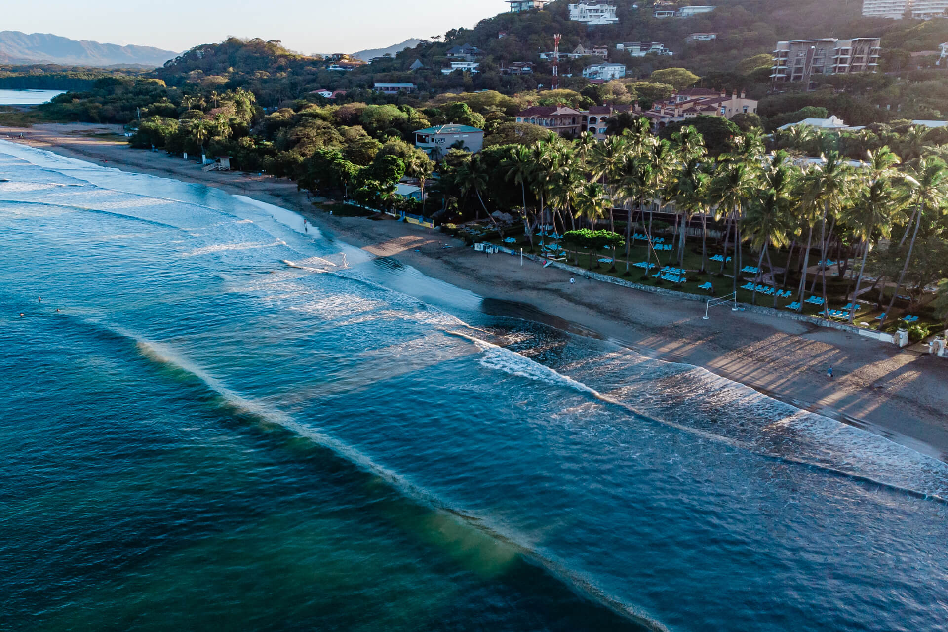 Bird’s-eye view of Tamarindo in Costa Rica, with its perfect waves and golden sandy beach lined with palm trees.