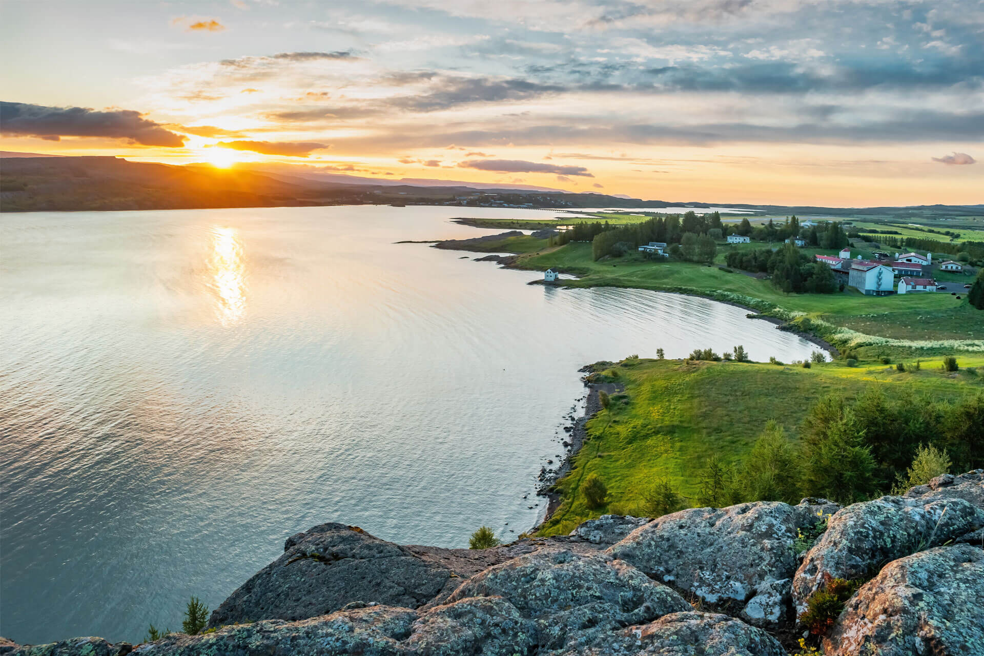 Panoramic view of the midnight sun over Egilsstaðir, along the banks of the Lagarfljót River in Iceland.