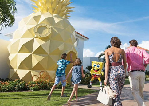 Une famille marche vers SpongeBob, un personnage phare du Nickelodeon Hotels & Resorts