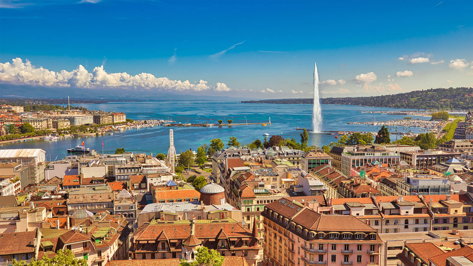 Vue panoramique de Genève en Suisse, bordant le lac Léman avec le Jet d’eau et les toits orangés des bâtiments historiques.