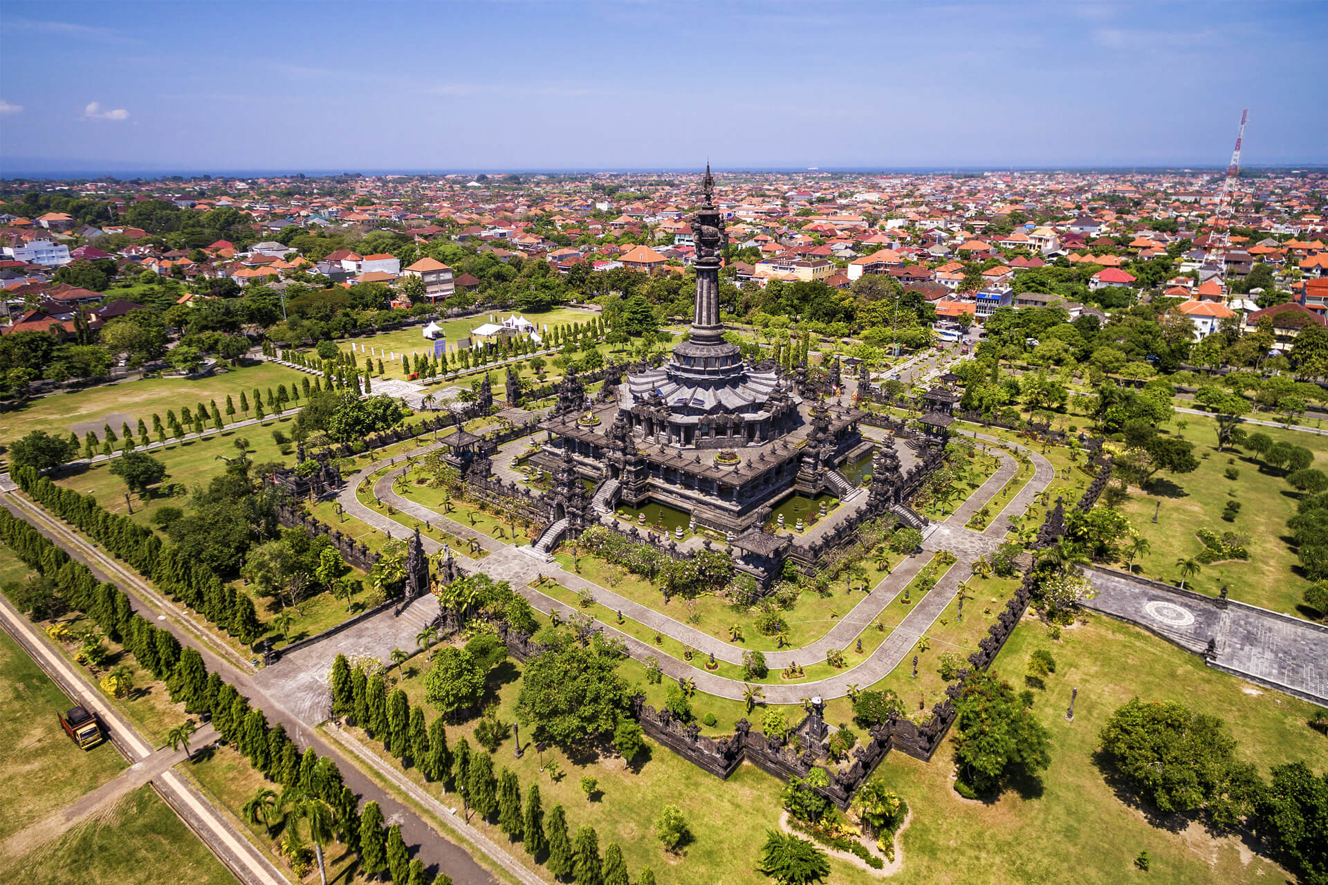 Aerial view of Bajra Sandhi monument in Denpasar, Bali, surrounded by green gardens and symmetrical tree-lined paths.
