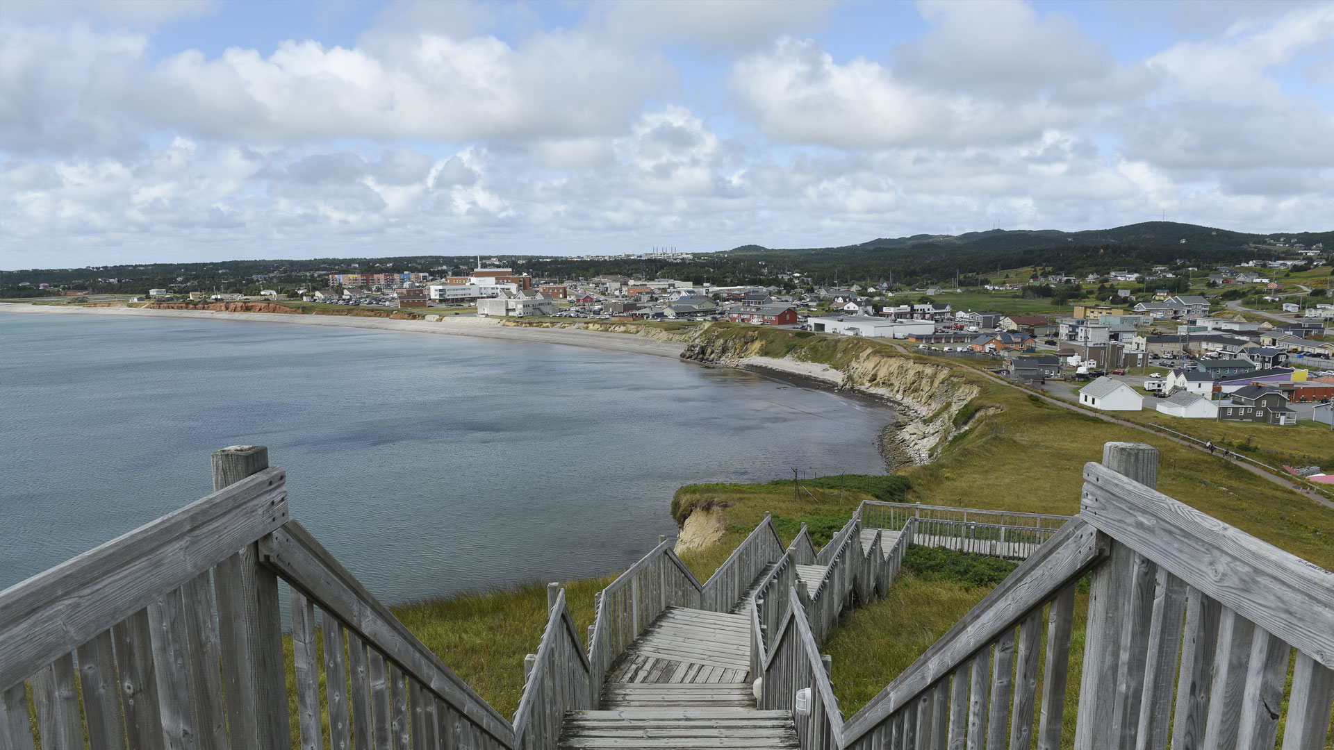 Wooden staircase overlooking the panoramic coastline and village of Cap-aux-Meules, Magdalen Islands.