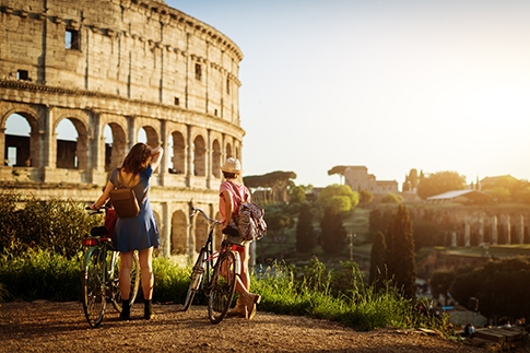 En visite à Rome à vélo, une femme et sa fille s’arrêtent près du célèbre Colisée.