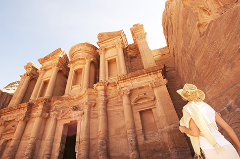 Une femme admire le Kazneh, monument emblématique de Pétra en Jordanie.