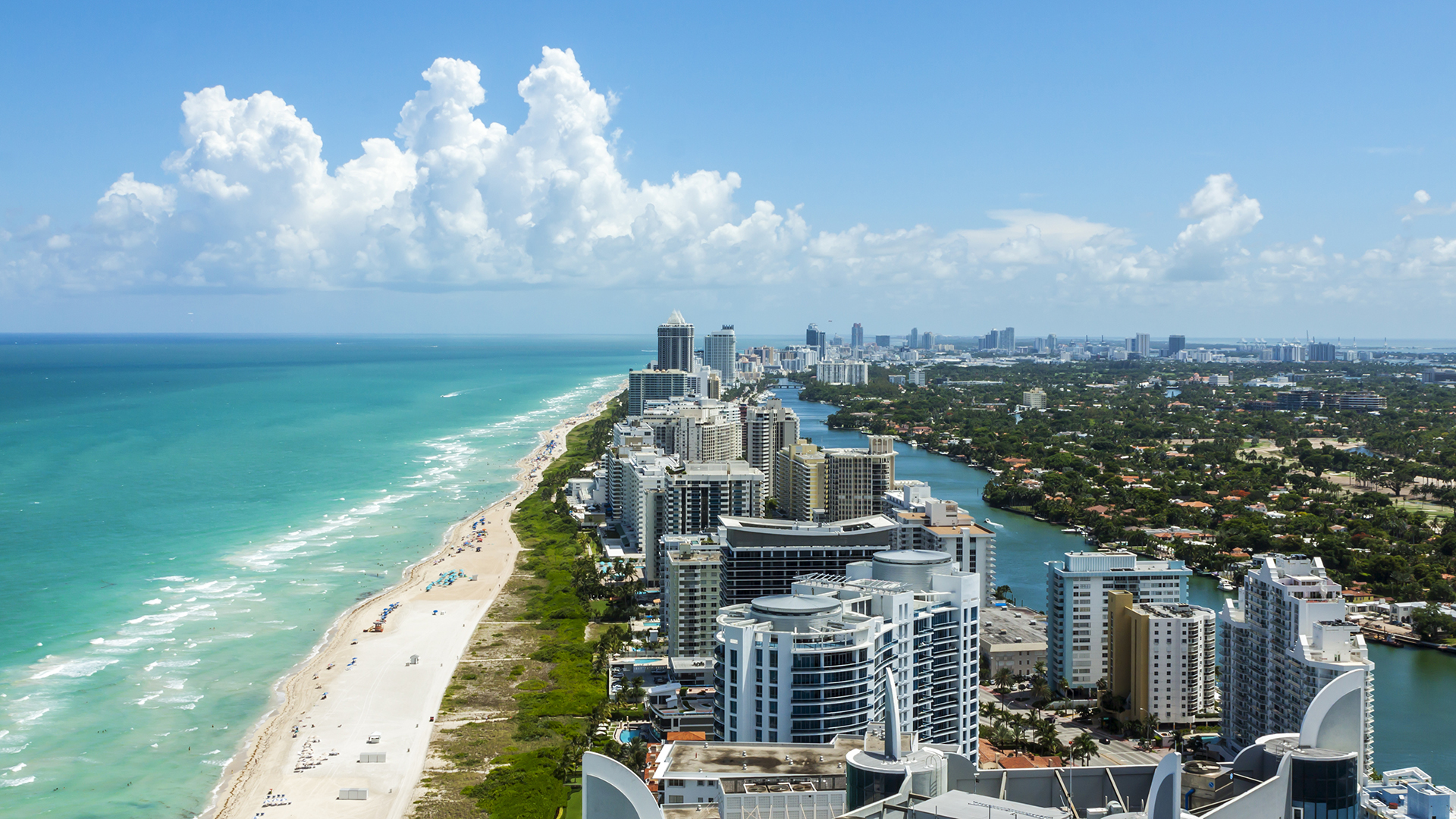 Aerial view of Miami, Florida, with white-sand beaches, turquoise waters, and skyscrapers along the Atlantic Ocean.