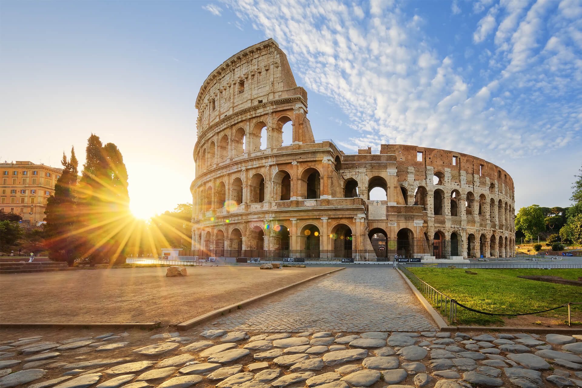 Rome’s Colosseum at sunrise, bathed in golden light and surrounded by ancient cobblestones.