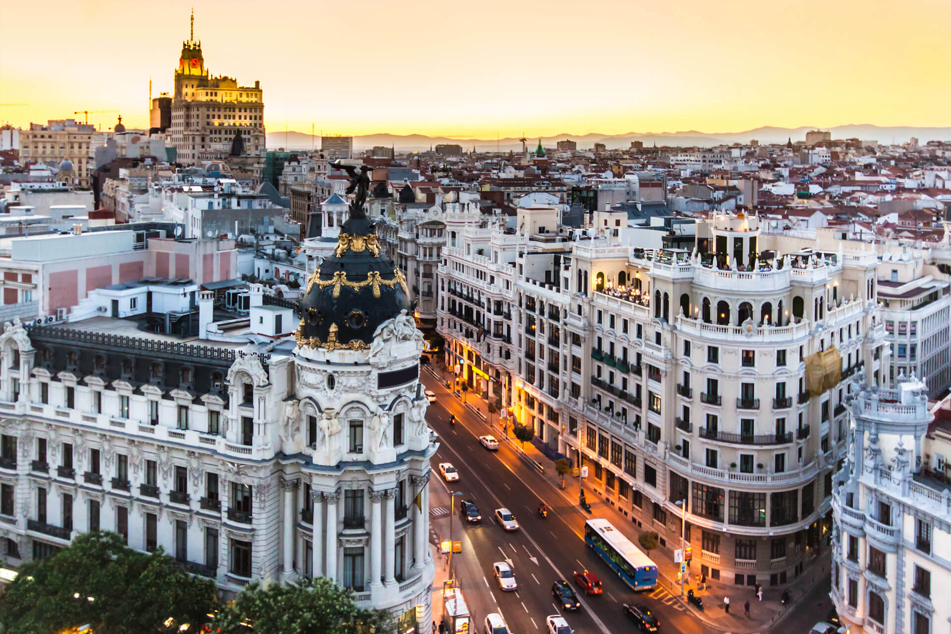 Vue aérienne de la Gran Vía à Madrid, en Espagne, au coucher du soleil, avec le bâtiment Metropolis et son dôme d'ardoise noire.