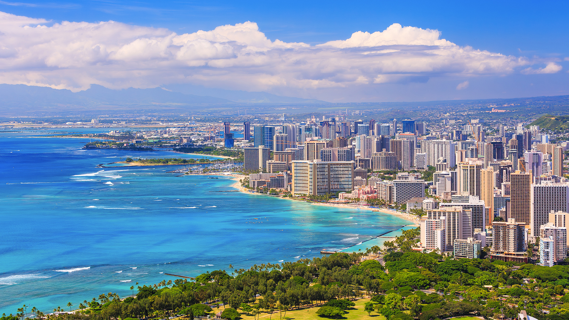 Vue aérienne de la ville d’Honolulu, capitale d’Hawaï, avec des paysages verdoyants et ses édifices situés en bordure de mer.