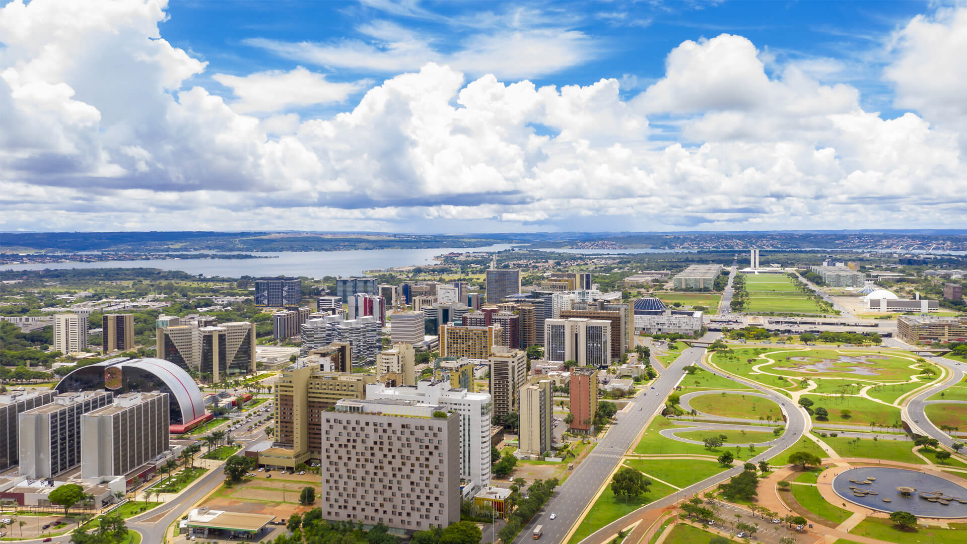 Aerial view of Brasilia, Brazil, showing geometric avenues, modernist buildings, and large green spaces.