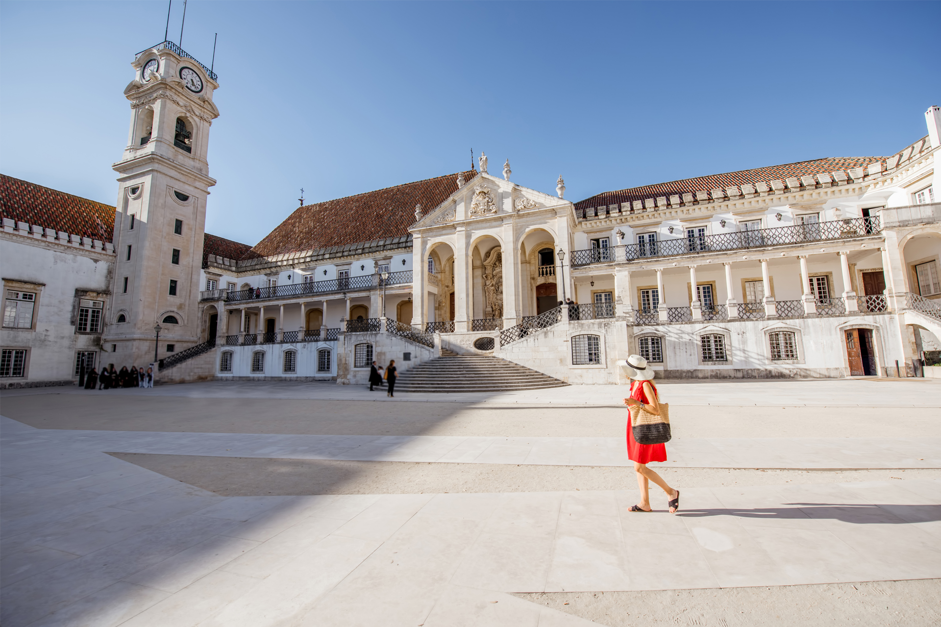 Courtyard of the University of Coimbra in Portugal, featuring its historic clock tower and baroque architecture.