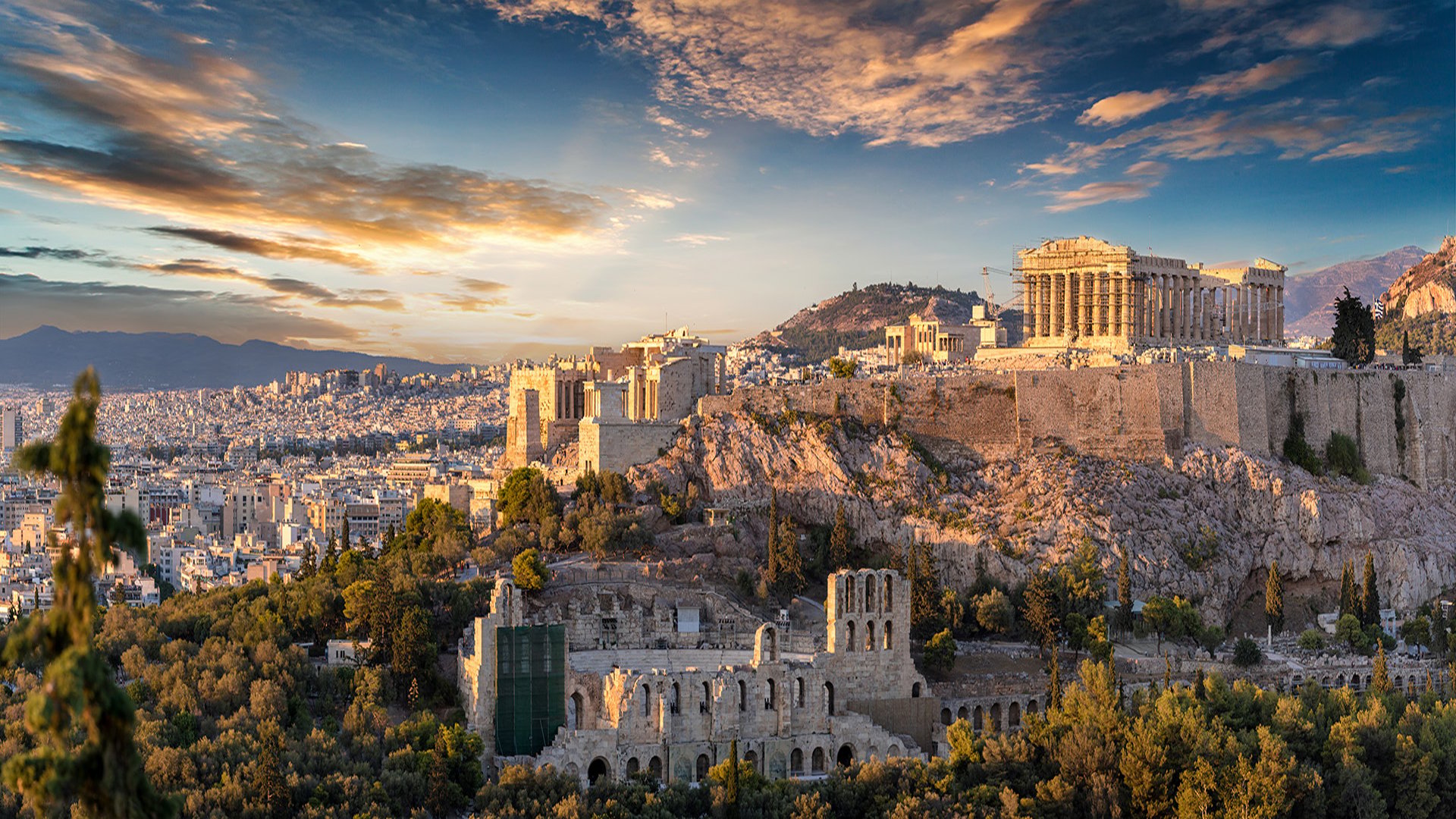 Panoramic view of the Acropolis of Athens, Greece, at sunset, with the Parthenon overlooking the ancient city. 