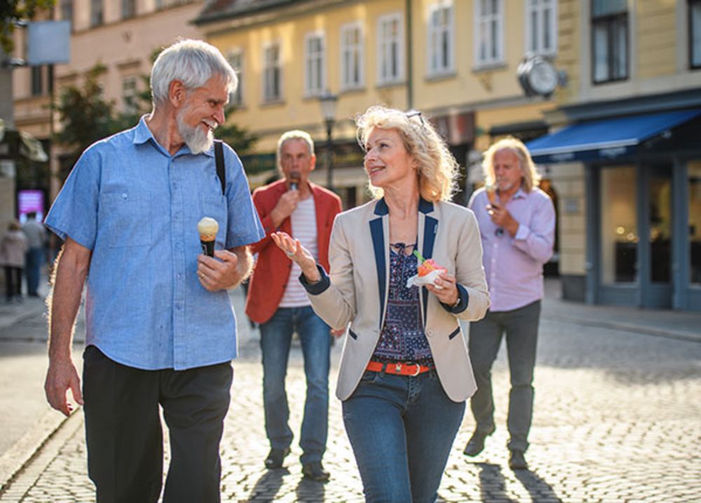Un couple en vacances en Europe déguste une glace en marchant.