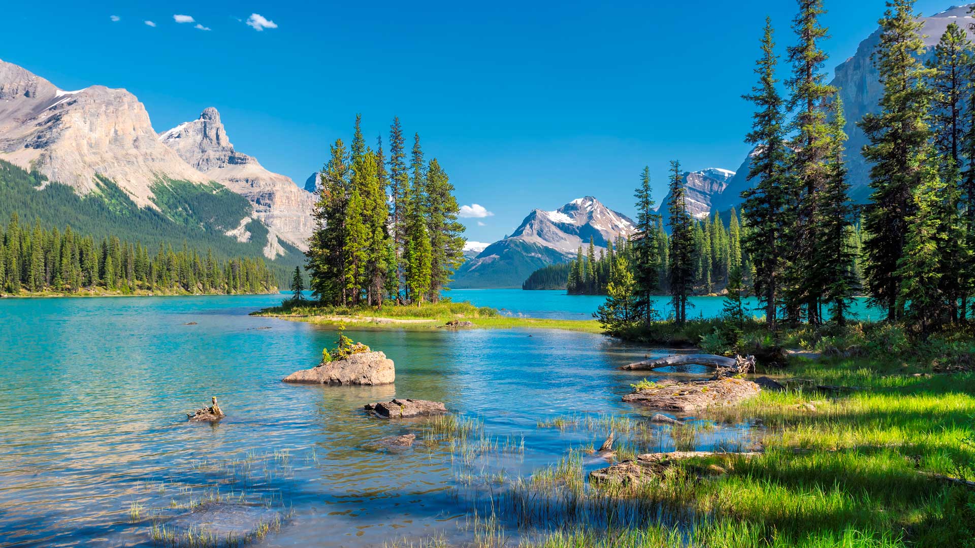 Maligne Lake in Jasper with turquoise water and Spirit Island, and the Canadian Rockies rising in the background.